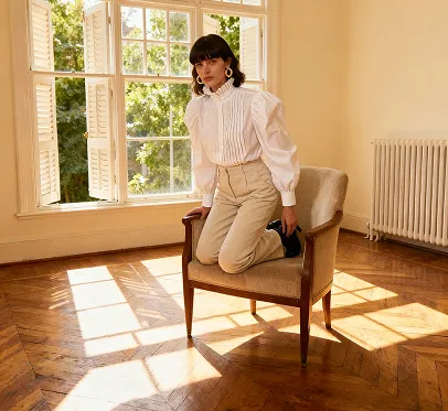 Troque as roupas da mulher da foto por um suéter e mude o fundo para um campo florido e quente.
